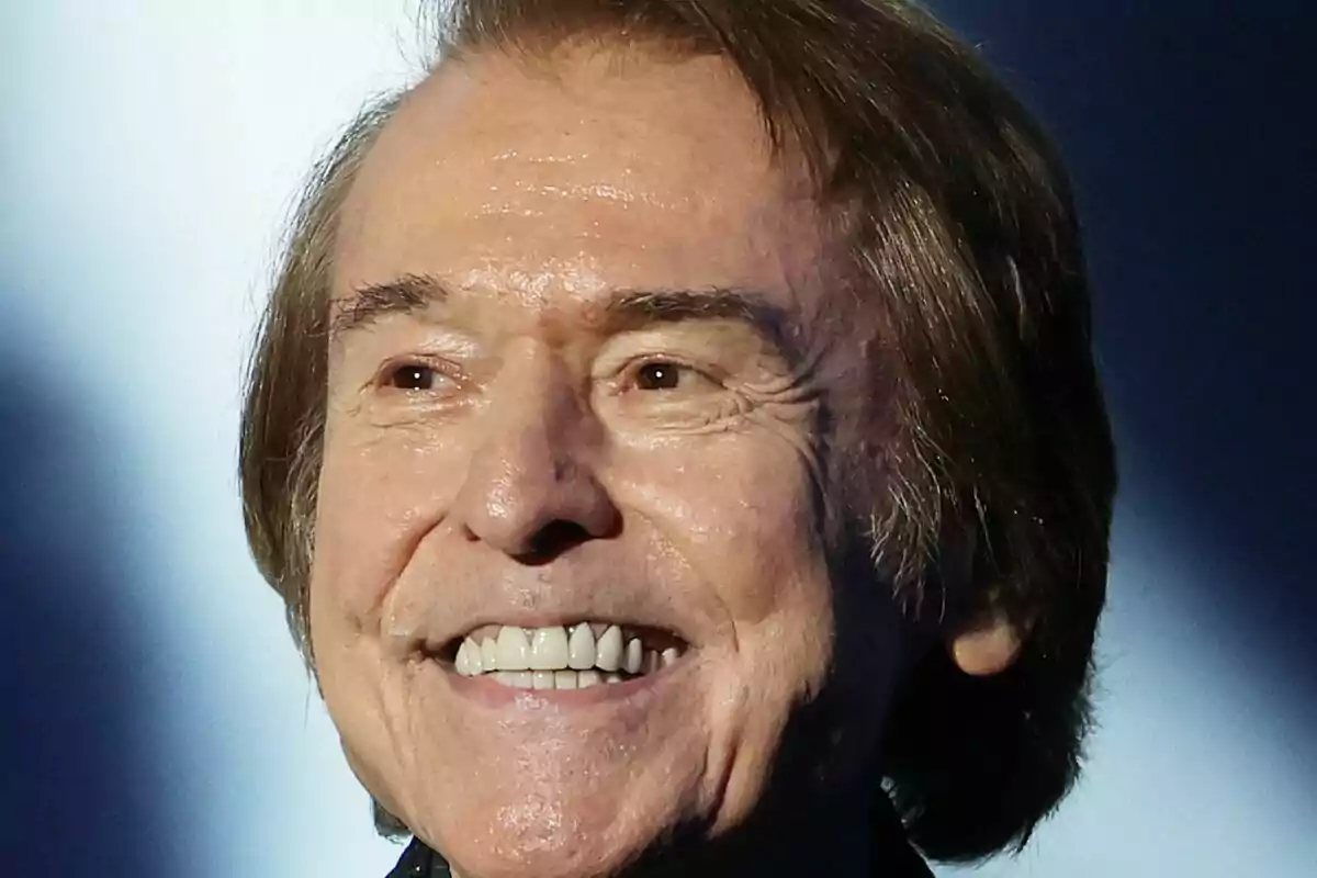 Primer plano de Raphael sonriente sobre un fondo desenfocado. Primer plano de Raphael sonriente sobre un fondo desenfocado.