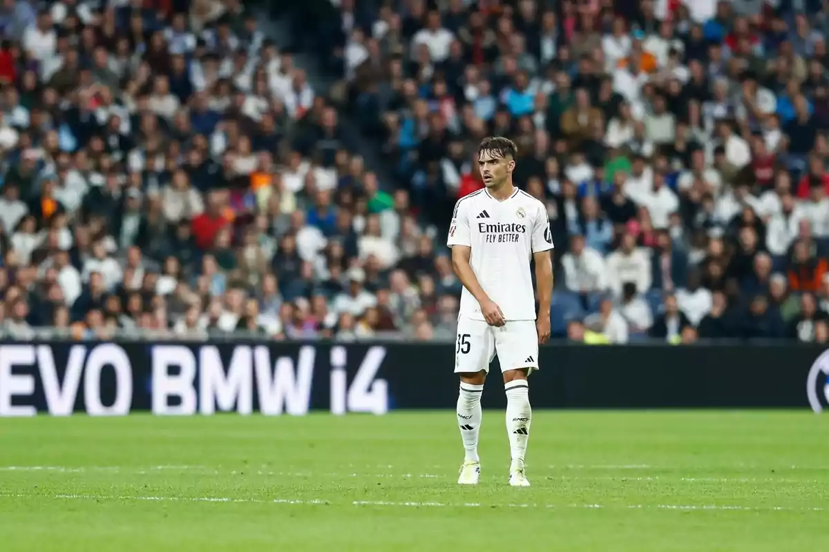 A soccer player wearing the white Real Madrid uniform was on the field during a party with a large number of spectators.