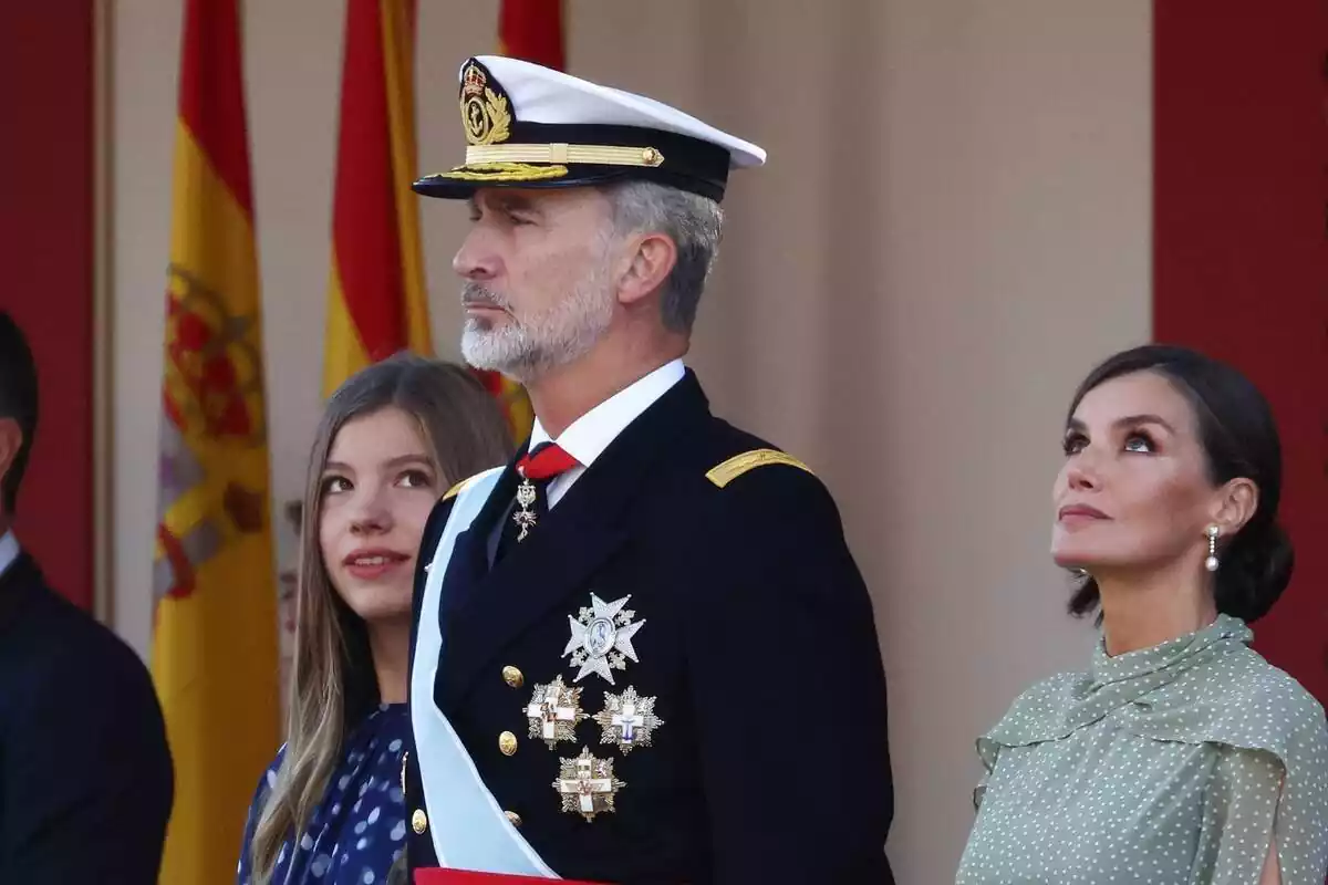 Plano medio del rey Felipe VI con cara seria en el desfile militar del 12 de octubre con la reina Letizia a su lado izquierdo mirando al cielo y la infanta Sofía a su derecha mirando a su padre