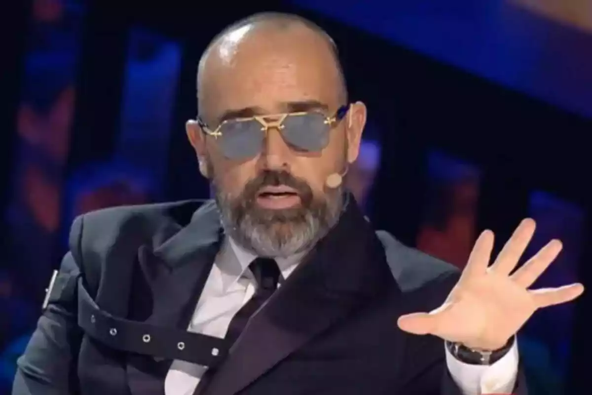 Risto Mejide con barba y gafas de sol está hablando mientras gesticula con la mano en Got Talent.