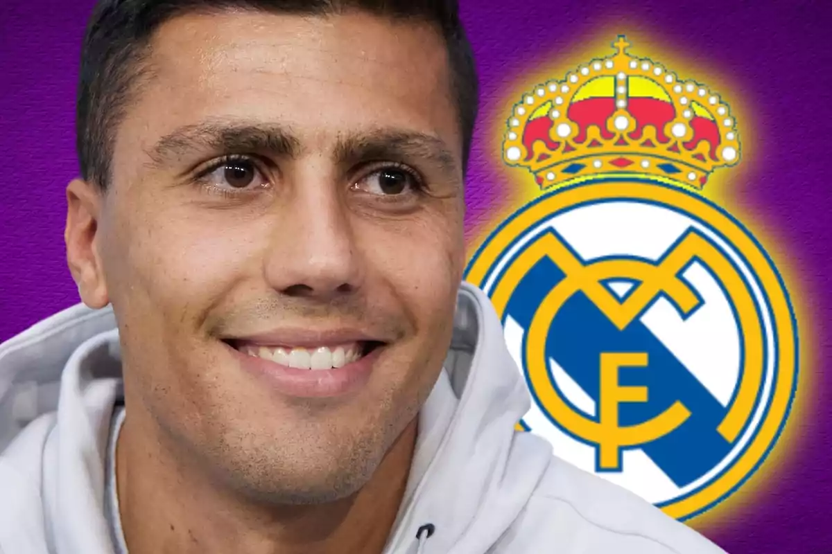 Un hombre sonriendo con el logo del Real Madrid de fondo.