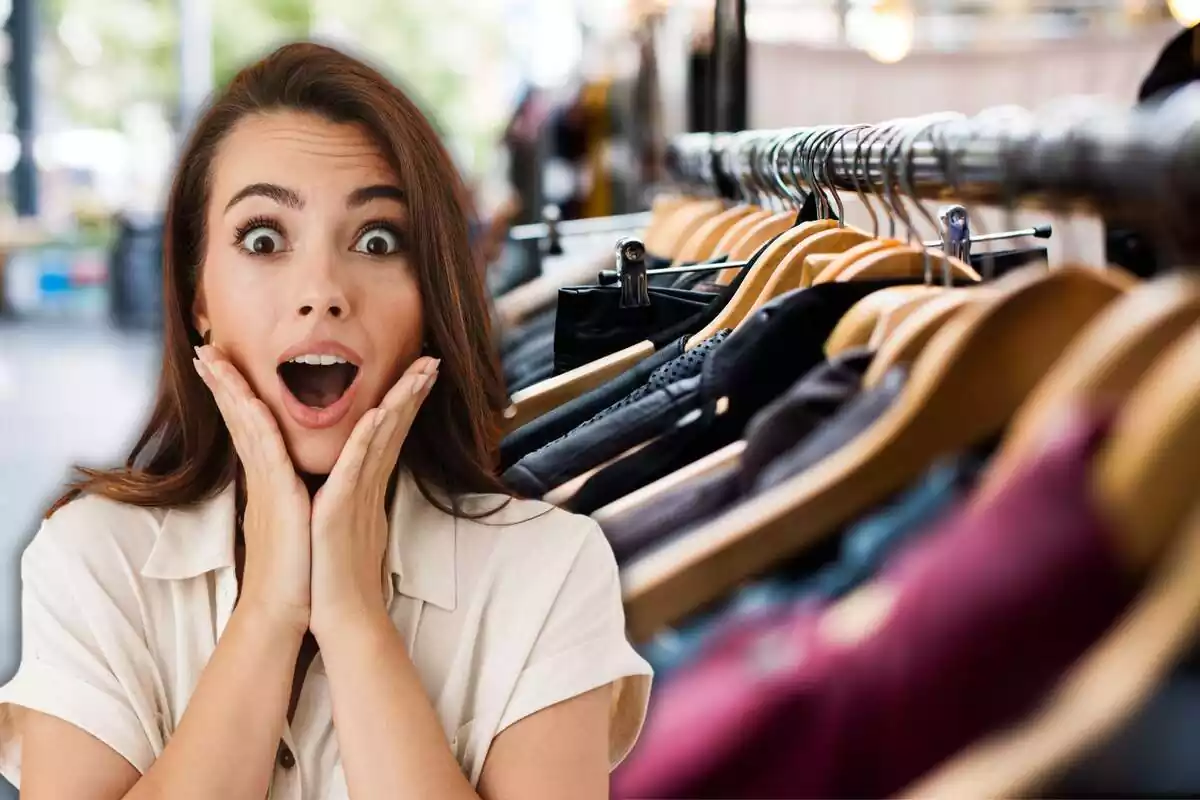 Una chica sorprendida con las manos en la cara y perchas con ropa en la calle