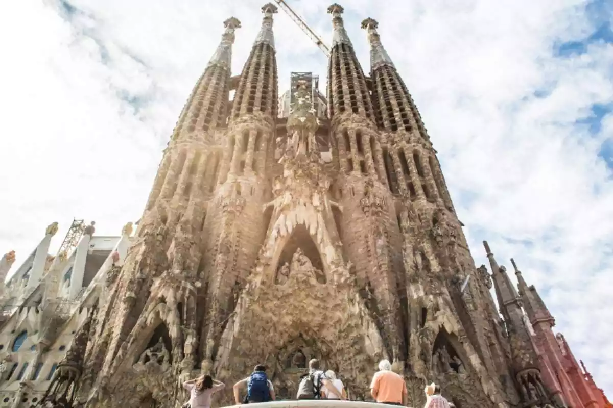 Turistas de pie mirando la Sagrada Familia
