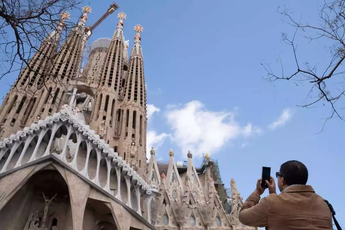 Turista haciendo una foto a la Sagrada Familia Turista haciendo una foto a la Sagrada Familia