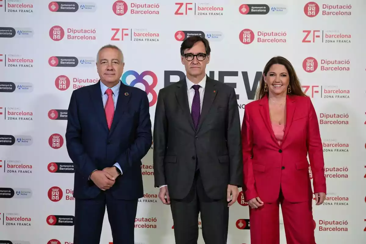 Tres personas posan frente a un fondo con logotipos de la Diputación de Barcelona y el Consorcio de la Zona Franca, una de ellas, es Salvador Illa.