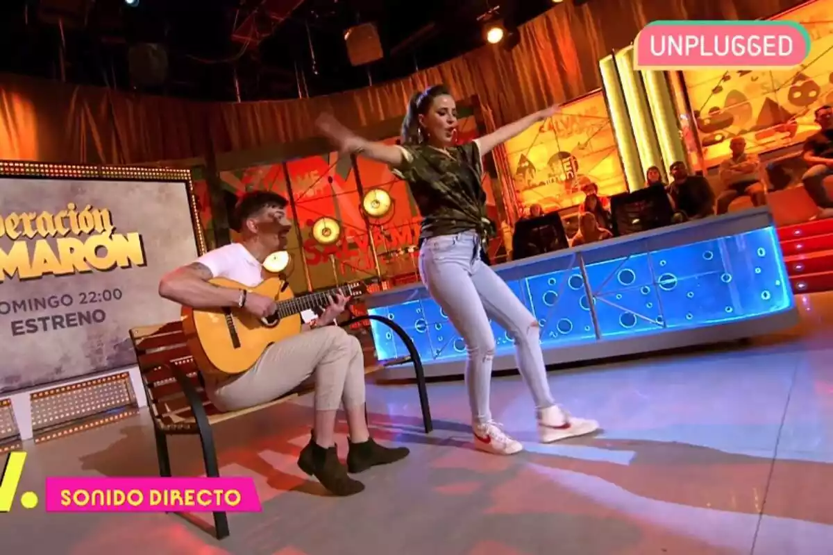 Captura de 'Sálvame' con Luitingo tocando la guitarra sentado y Carmen Alcayde bailando Captura de 'Sálvame' con Luitingo tocando la guitarra sentado y Carmen Alcayde bailando