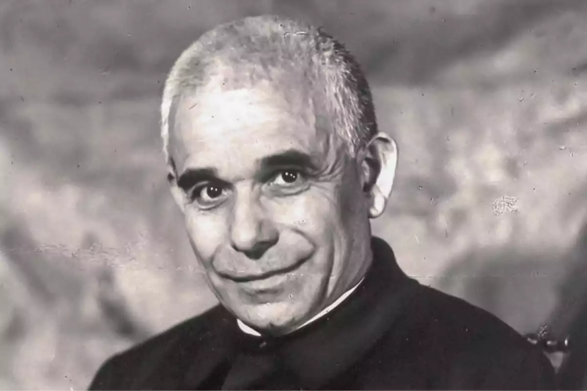 Un hombre mayor con cabello canoso y expresión amable, vestido con ropa oscura, en una fotografía en blanco y negro. Un hombre mayor con cabello canoso y expresión amable, vestido con ropa oscura, en una fotografía en blanco y negro.