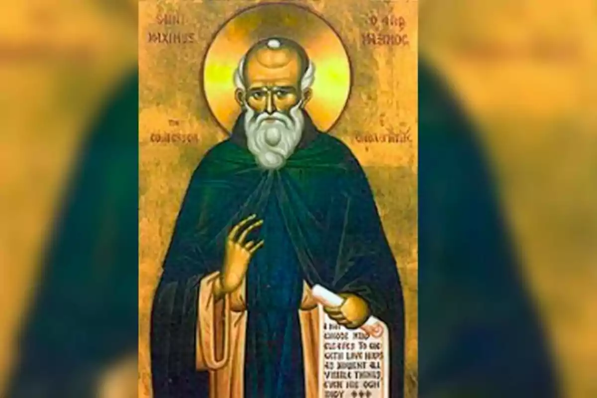 Una imagen de un icono religioso que muestra a un hombre con barba blanca y halo dorado, vestido con túnica oscura y sosteniendo un pergamino.