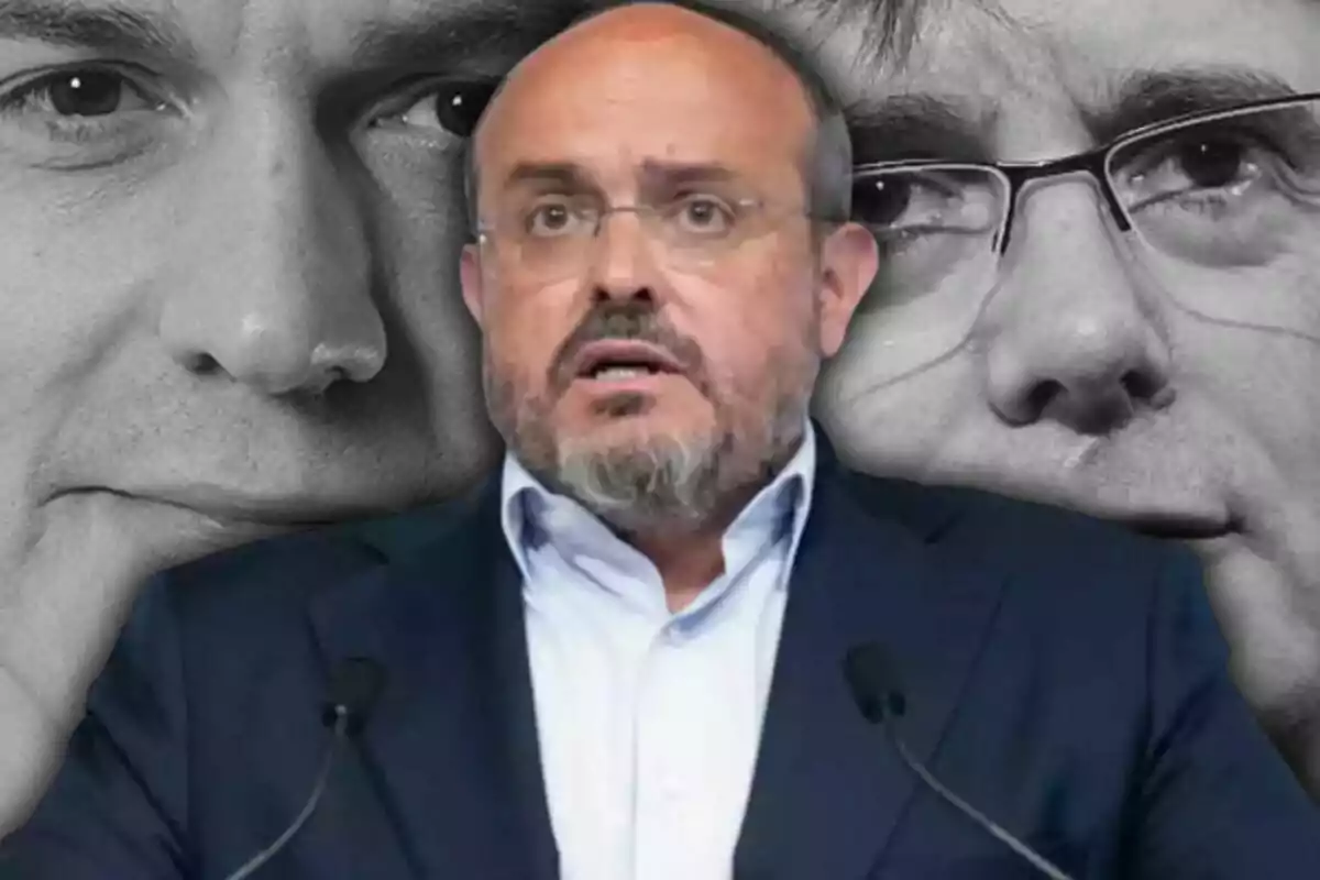 Hombre calvo con barba y gafas hablando frente a dos rostros en blanco y negro de fondo