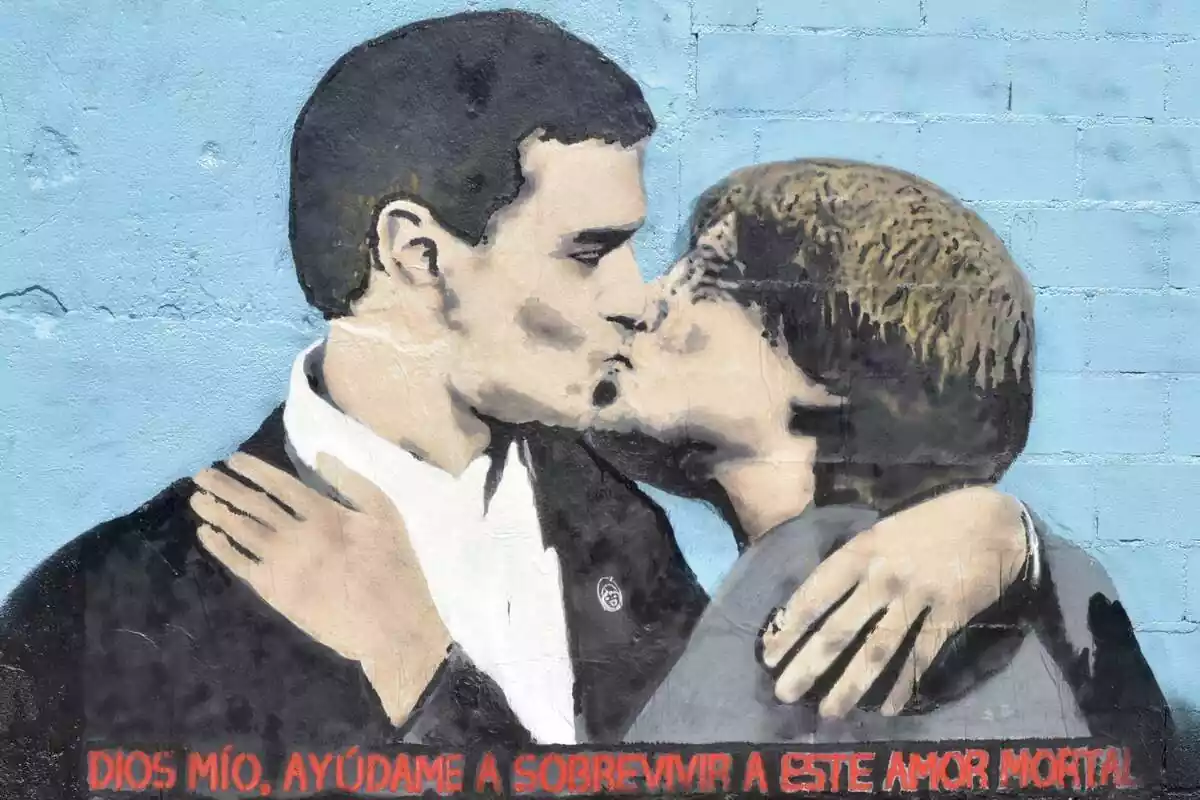 Graffitti de Tvboy de Pedro Sánchez y Carles Puigdemont dándose un beso en la boca