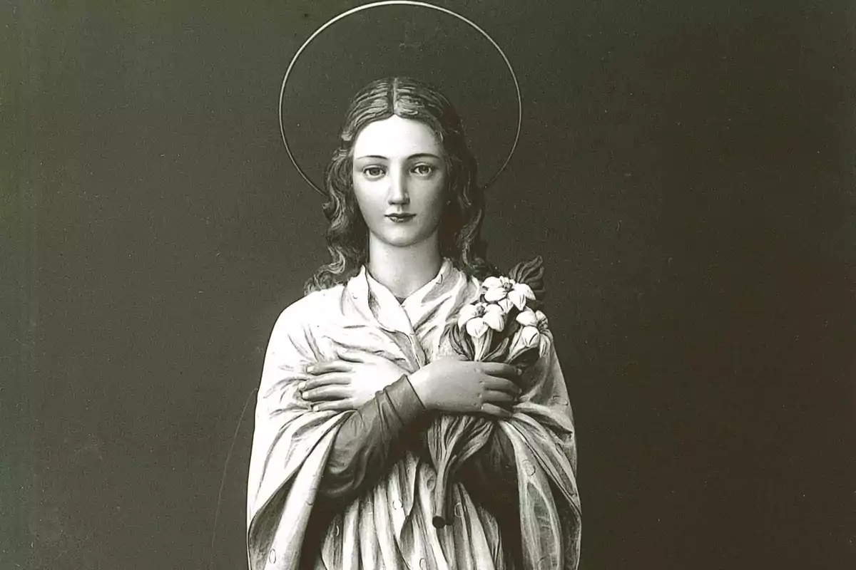 Estatua de una mujer con halo y flores en la mano.