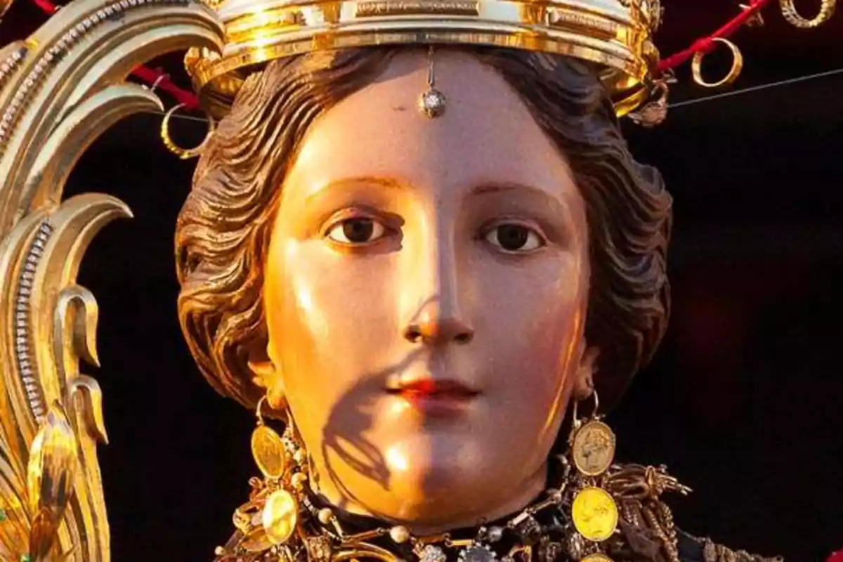 Una estatua religiosa con una corona dorada y adornos detallados. Una estatua religiosa con una corona dorada y adornos detallados.