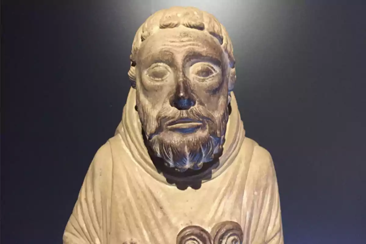 Escultura de un monje con capucha y barba en un fondo oscuro. Escultura de un monje con capucha y barba en un fondo oscuro.