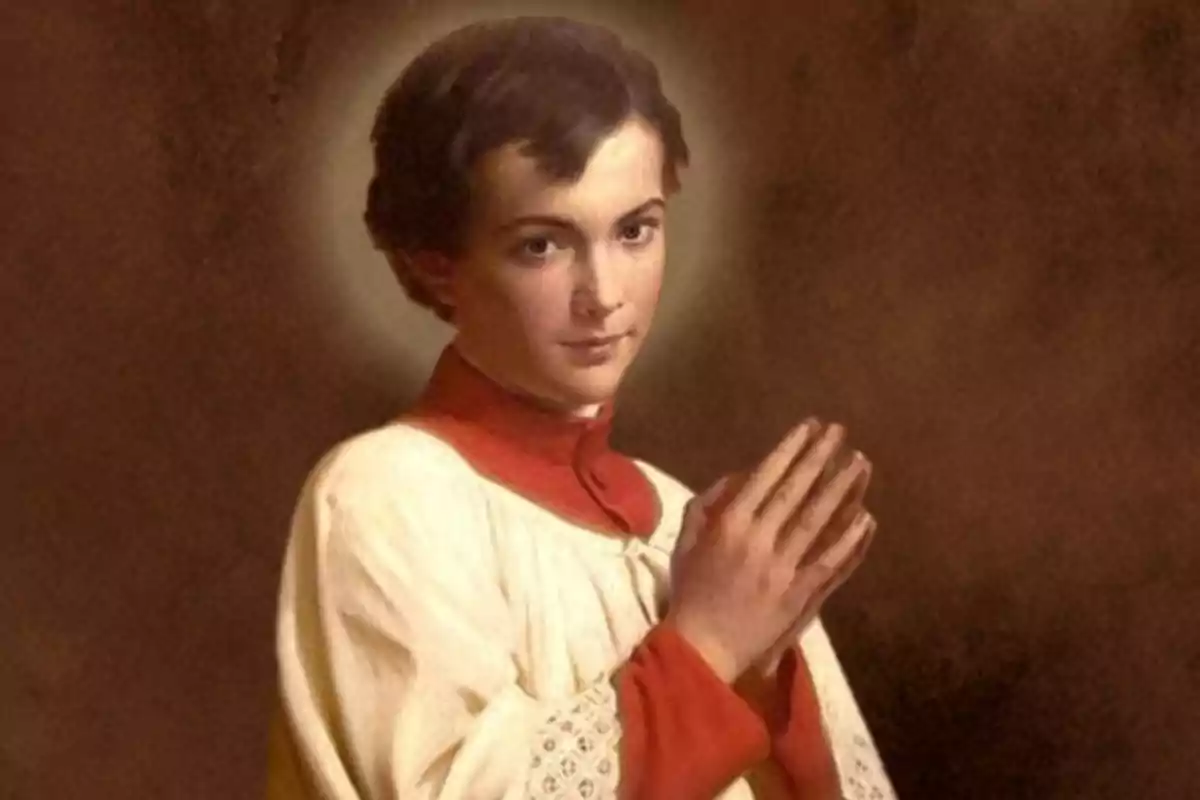 Un joven con vestimenta religiosa y un halo sobre su cabeza está en actitud de oración.