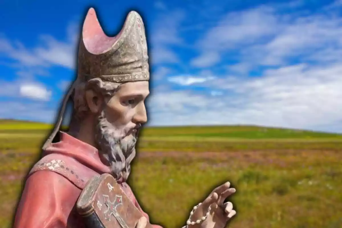 Estatua de San Froilán de León con una imagen difuminada de fondo de un campo