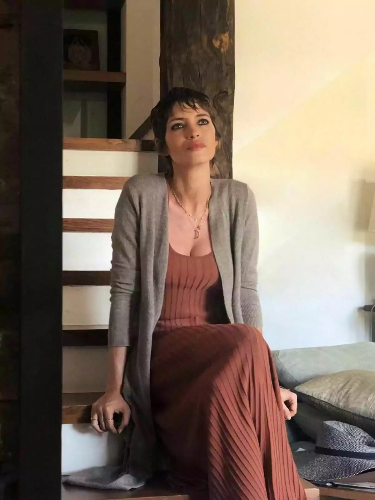 Sara Carbonero seria con un vestido marrón y una chaqueta sentada en unas escaleras Sara Carbonero seria con un vestido marrón y una chaqueta sentada en unas escaleras