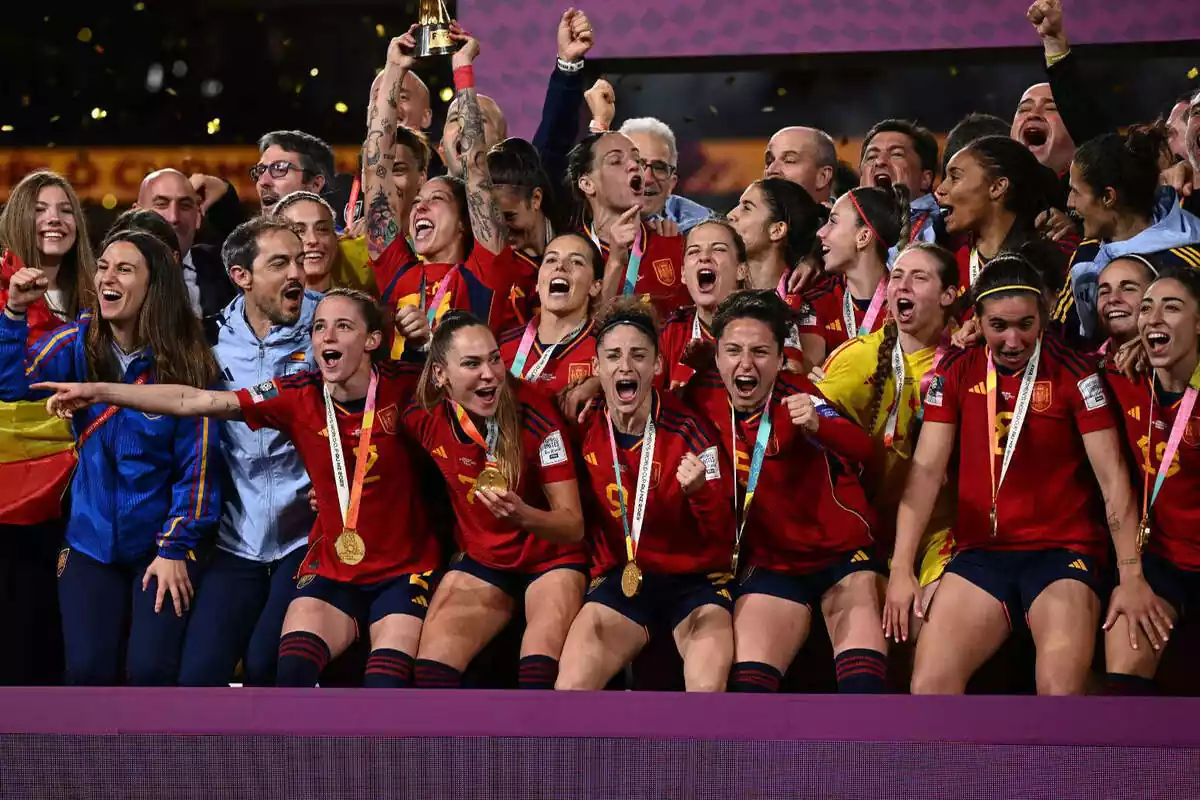 Foto de grupo de la selección española de fútbol femenino celebrando el Mundial, con las jugadoras abrazadas gritando