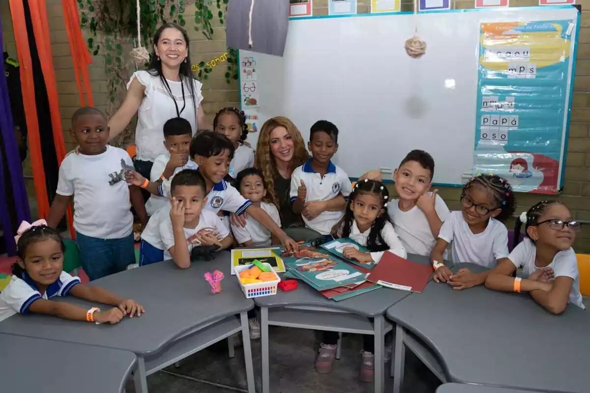Shakira posando sonriente con los niños de la nueva escuela inaugurada en Barranquilla gracias a la ayuda de la fundación La Caixa
