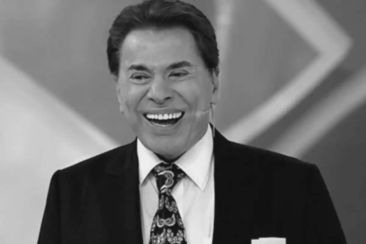 Fotografía en blanco y negro de Silvio Santos sonriendo con traje y corbata