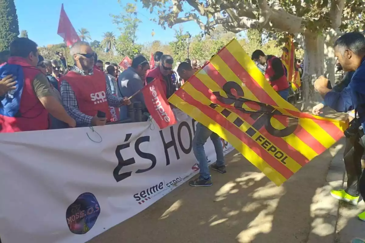 Varios sindicalistas de los Mossos protestas a las puertas del Parlament con banderas y petos del sindicato, una senyera y una pancarta