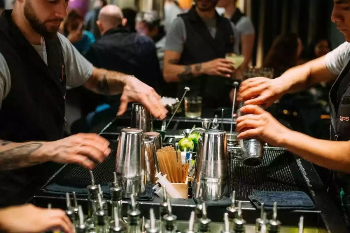 Imagen de dos trabajadores de la coctelería Sips de Barcelona preparando bebidas