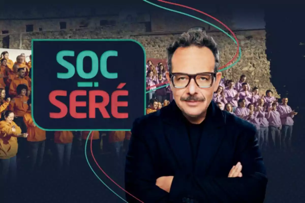 Àngel Llàcer con gafas y bigote está frente a un grupo de personas vestidas de naranja y morado, con un cartel que dice Àngel Llàcer con gafas y bigote está frente a un grupo de personas vestidas de naranja y morado, con un cartel que dice