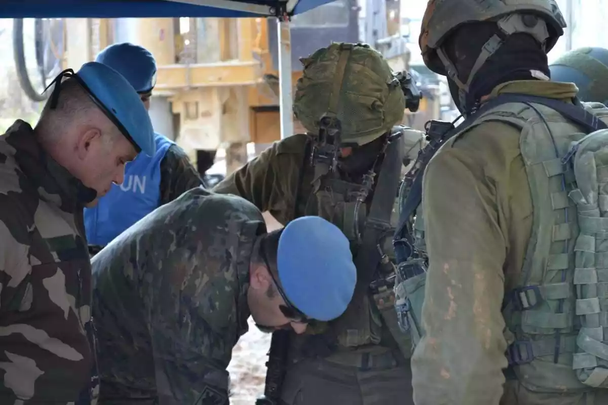 Dos oficiales de Naciones Unidas, un francés y un español, revisan unas perforaciones en presencia de soldados israelíes del Batallón Yahalom