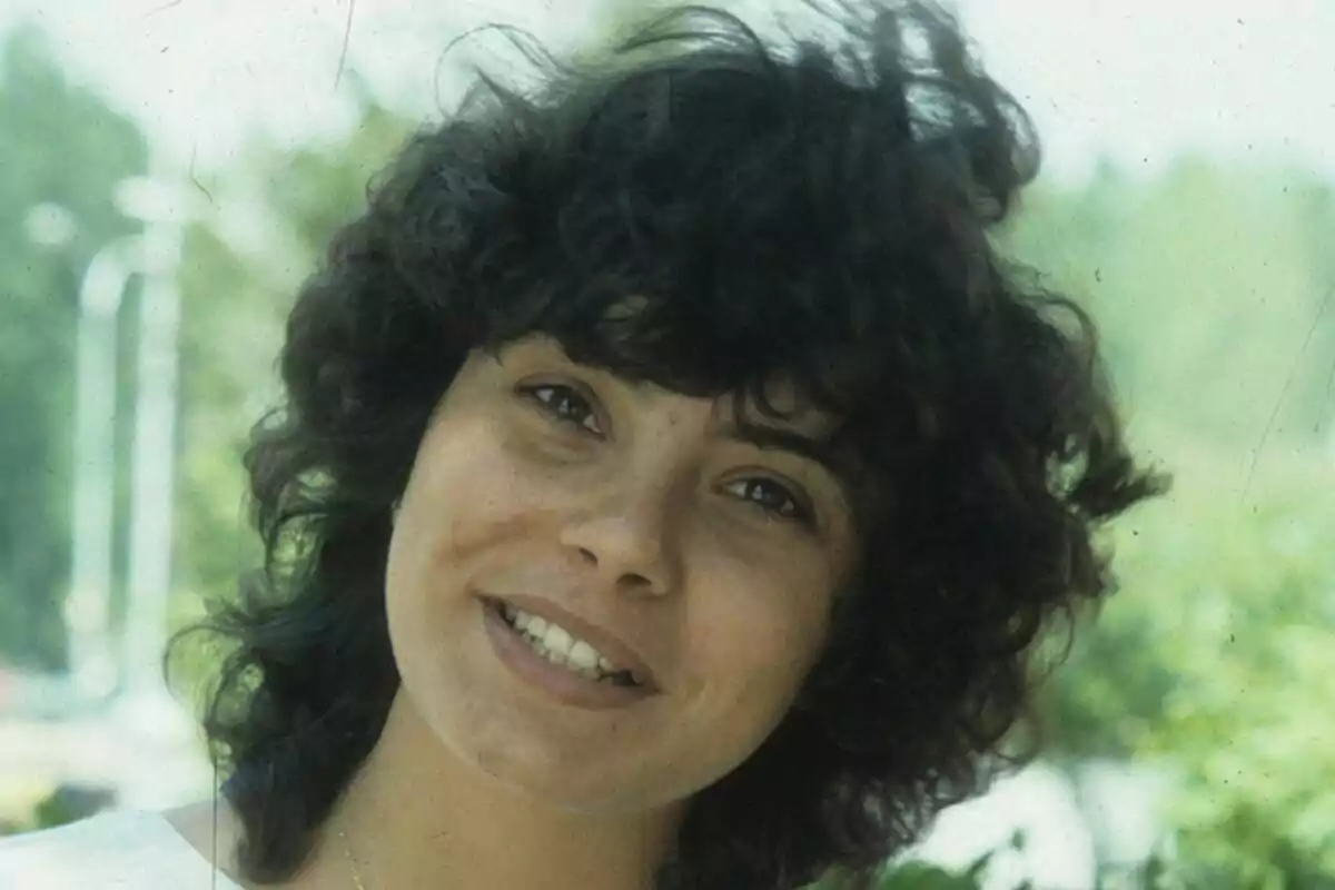 Sonia Martínez con cabello rizado sonriendo al aire libre.