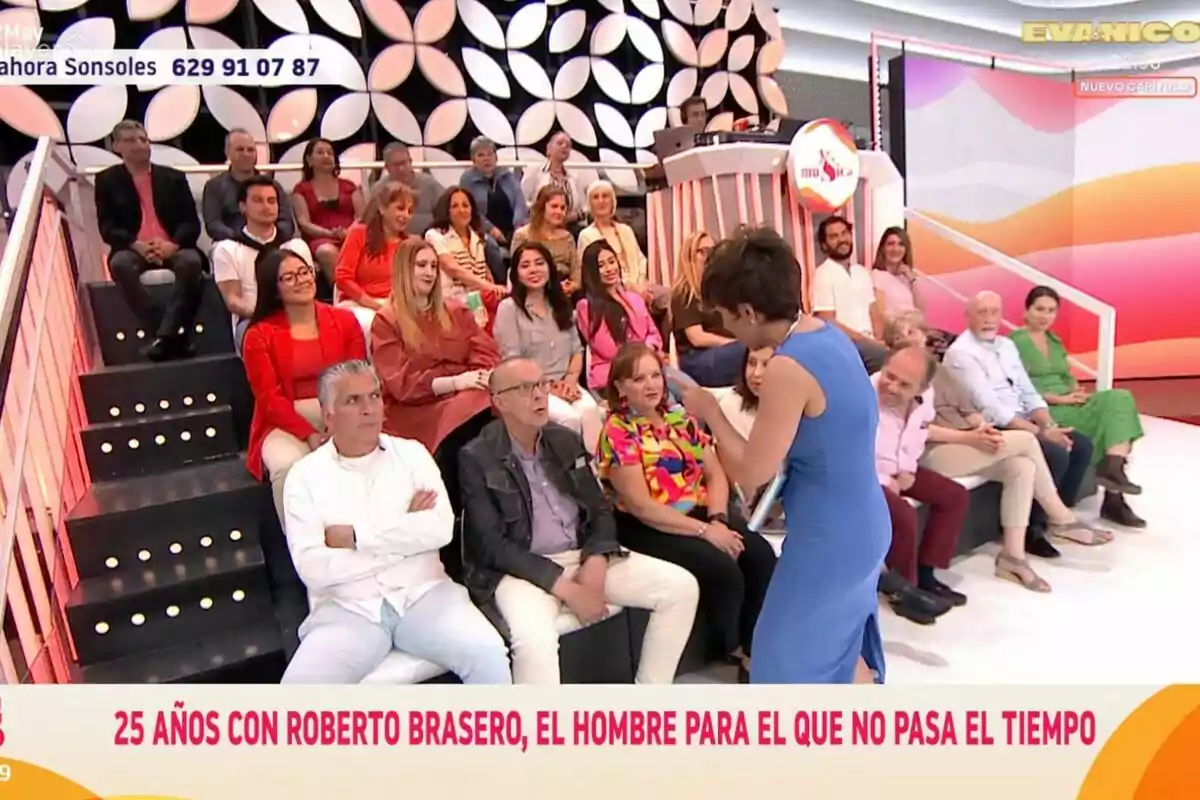 El público está sentado en 'Y ahora Sonsoles', mientras Sonsoles Ónega interactúa con el público; el fondo tiene un diseño geométrico y hay un mensaje en la parte inferior que menciona a Roberto Brasero. El público está sentado en 'Y ahora Sonsoles', mientras Sonsoles Ónega interactúa con el público; el fondo tiene un diseño geométrico y hay un mensaje en la parte inferior que menciona a Roberto Brasero.
