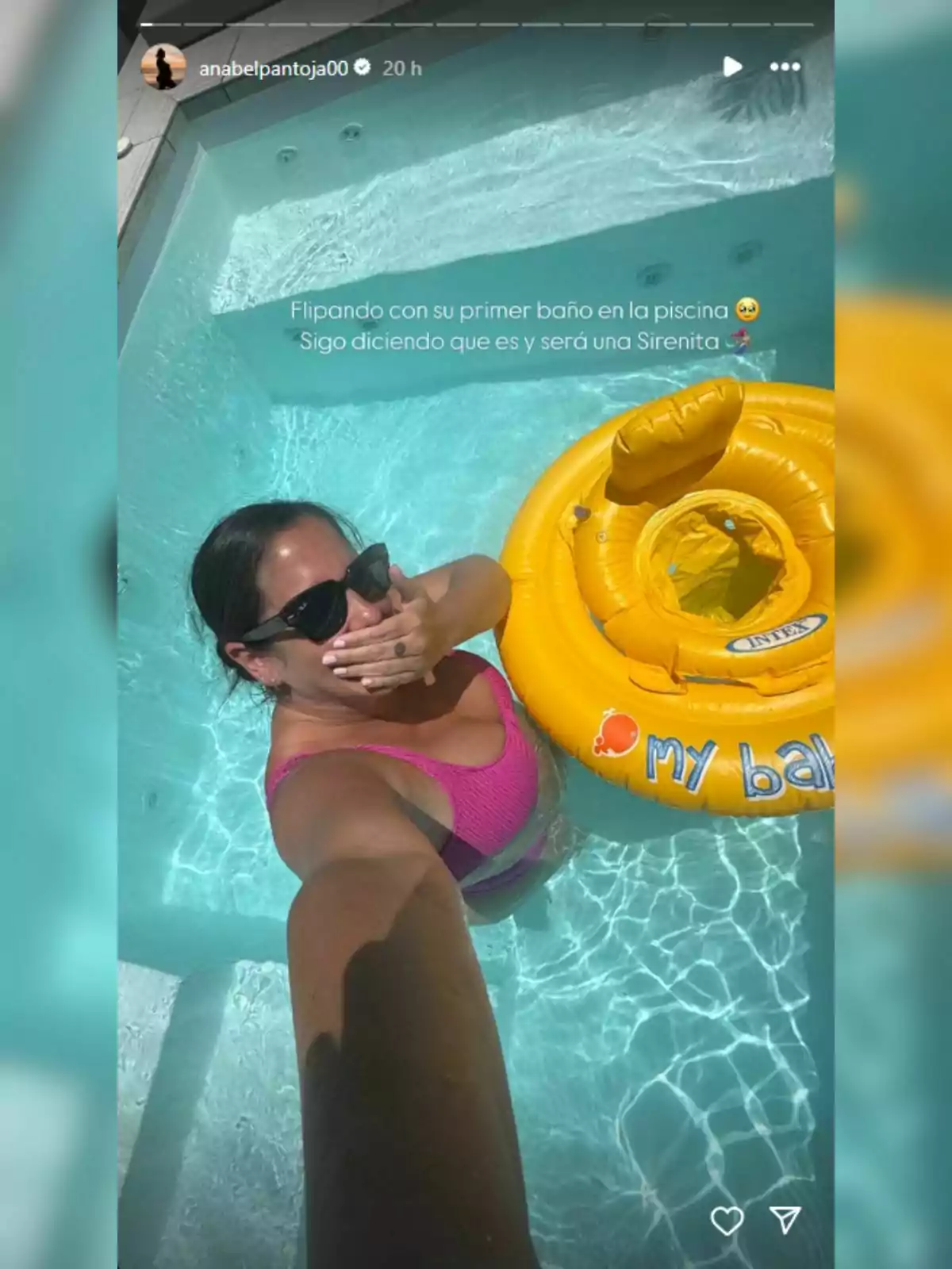 Anabel Pantoja en una piscina tomando una selfie, usando gafas de sol y un traje de baño rosa, junto a un flotador amarillo para bebé. Anabel Pantoja en una piscina tomando una selfie, usando gafas de sol y un traje de baño rosa, junto a un flotador amarillo para bebé.