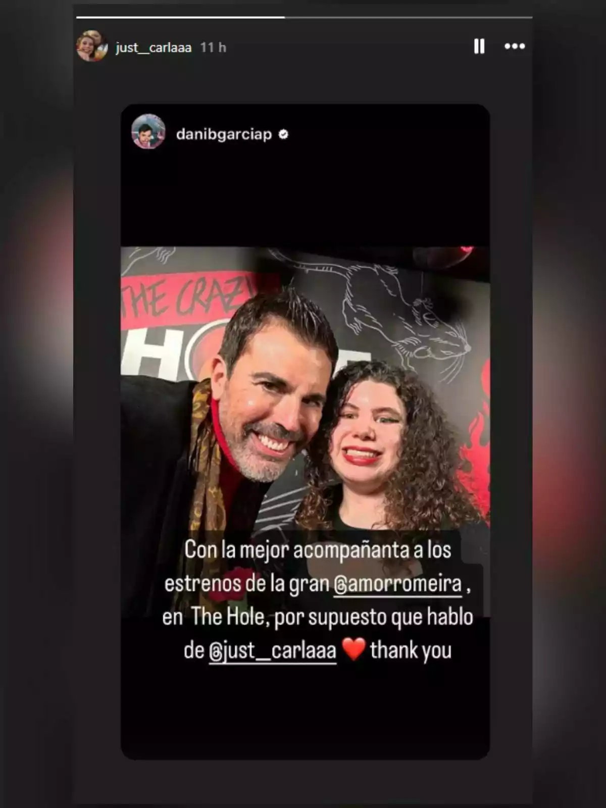 Carla Vigo, junto a un amigo, posa frente a un fondo con el texto 