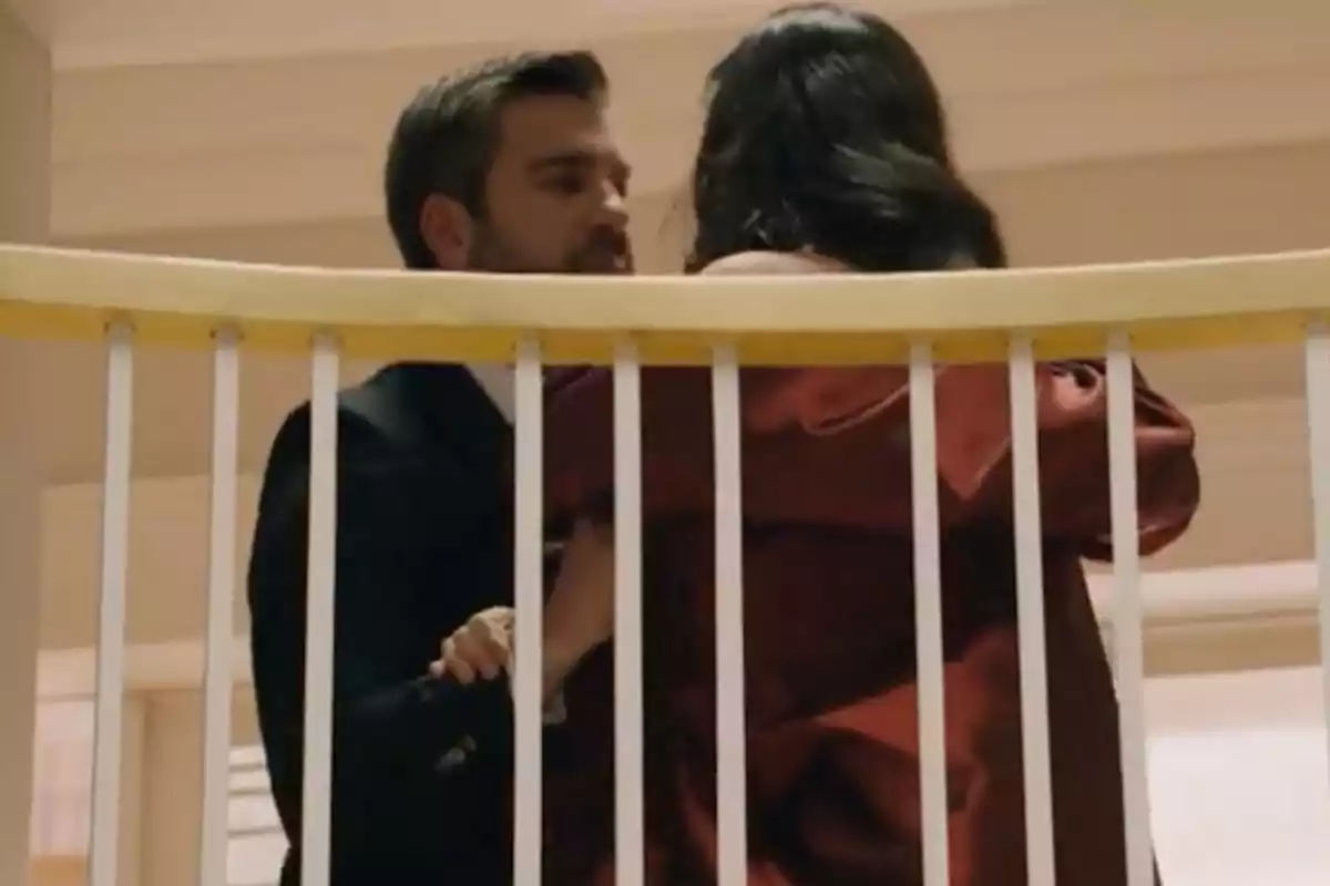 Andrés y una mujer abrazándose detrás de una barandilla blanca en el interior de un edificio. Captura de 'Sueños de libertad' Andrés y una mujer abrazándose detrás de una barandilla blanca en el interior de un edificio. Captura de 'Sueños de libertad'