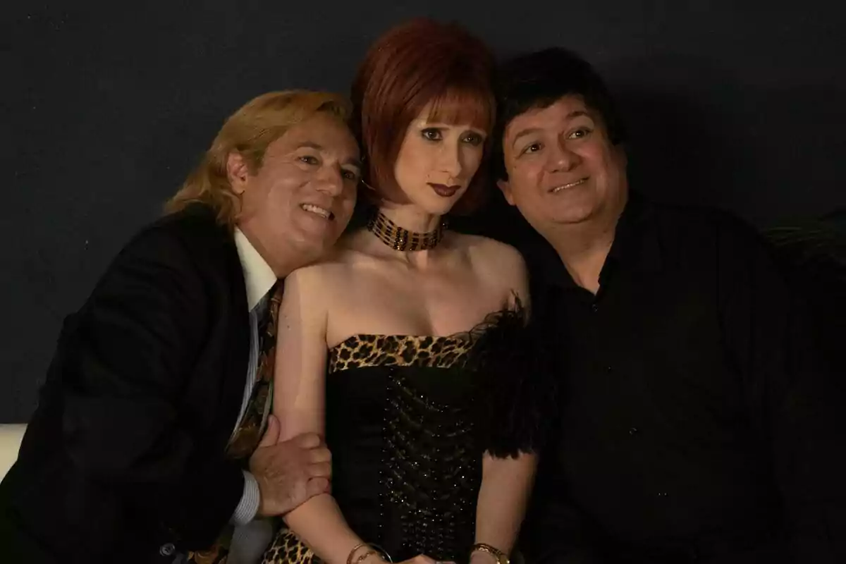 Ingrid Garcia-Jonsson como Yurenaa, Secun de la Rosa como Leonardo Dantés y Pepón Nieto como Tony Genil posan juntos, la del centro lleva un vestido de estampado animal print y los dos hombres a los lados sonríen mientras la rodean con los brazos en la serie Superestar Ingrid Garcia-Jonsson como Yurenaa, Secun de la Rosa como Leonardo Dantés y Pepón Nieto como Tony Genil posan juntos, la del centro lleva un vestido de estampado animal print y los dos hombres a los lados sonríen mientras la rodean con los brazos en la serie Superestar