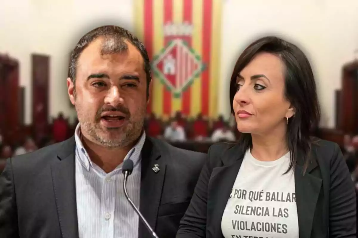 Dos personas en un entorno formal, una de ellas hablando frente a un micrófono y la otra mirando hacia él, con una bandera de fondo.