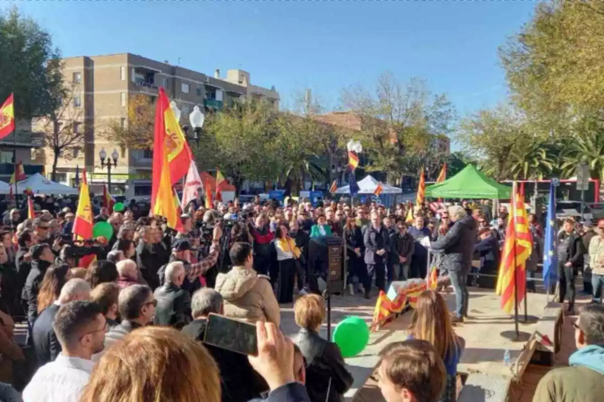 Plano general del acto por la Constitución con centenares de personas agrupadas alrededor de un escenario, donde una persona lee un comunicado