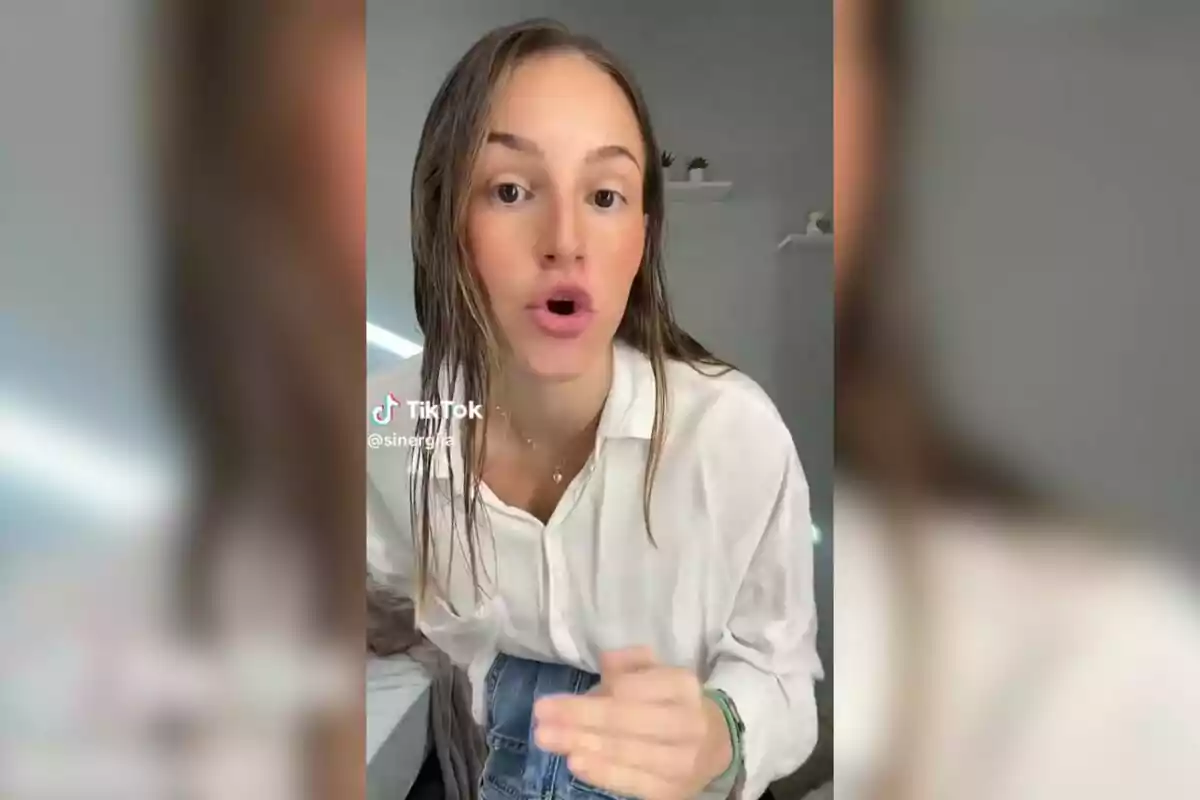 Una persona con cabello mojado y camisa blanca habla frente a la cámara en un video de TikTok.