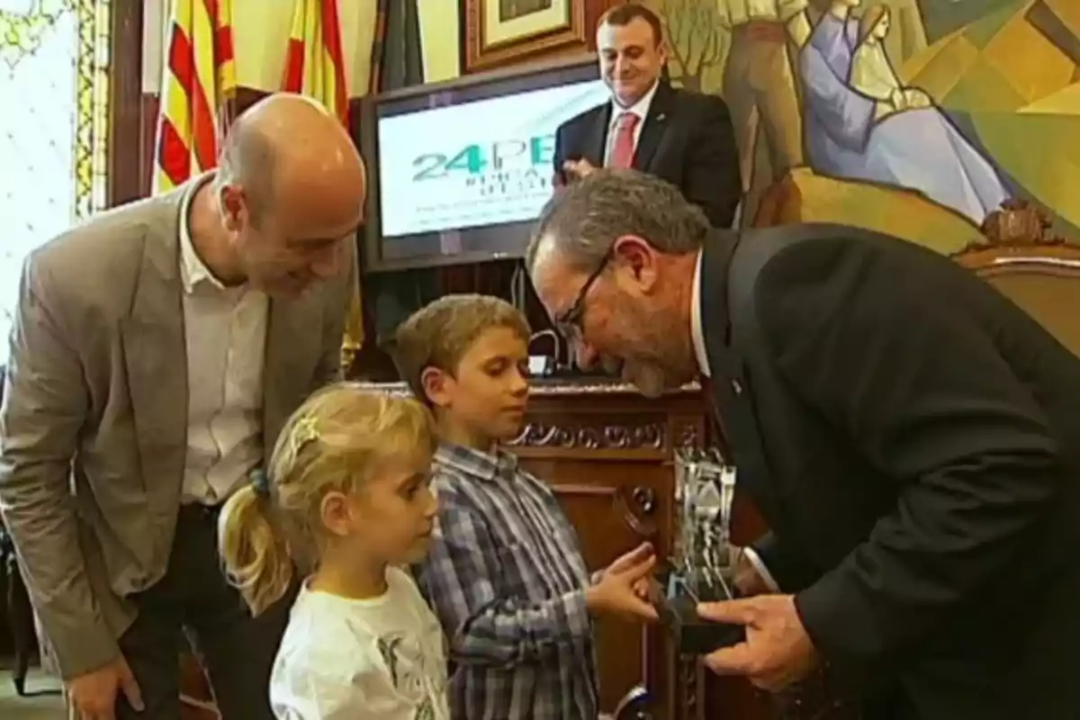 Un hombre mayor entrega un trofeo a los hijos de Toni Nadal mientras Tomás Molina observa Un hombre mayor entrega un trofeo a los hijos de Toni Nadal mientras Tomás Molina observa