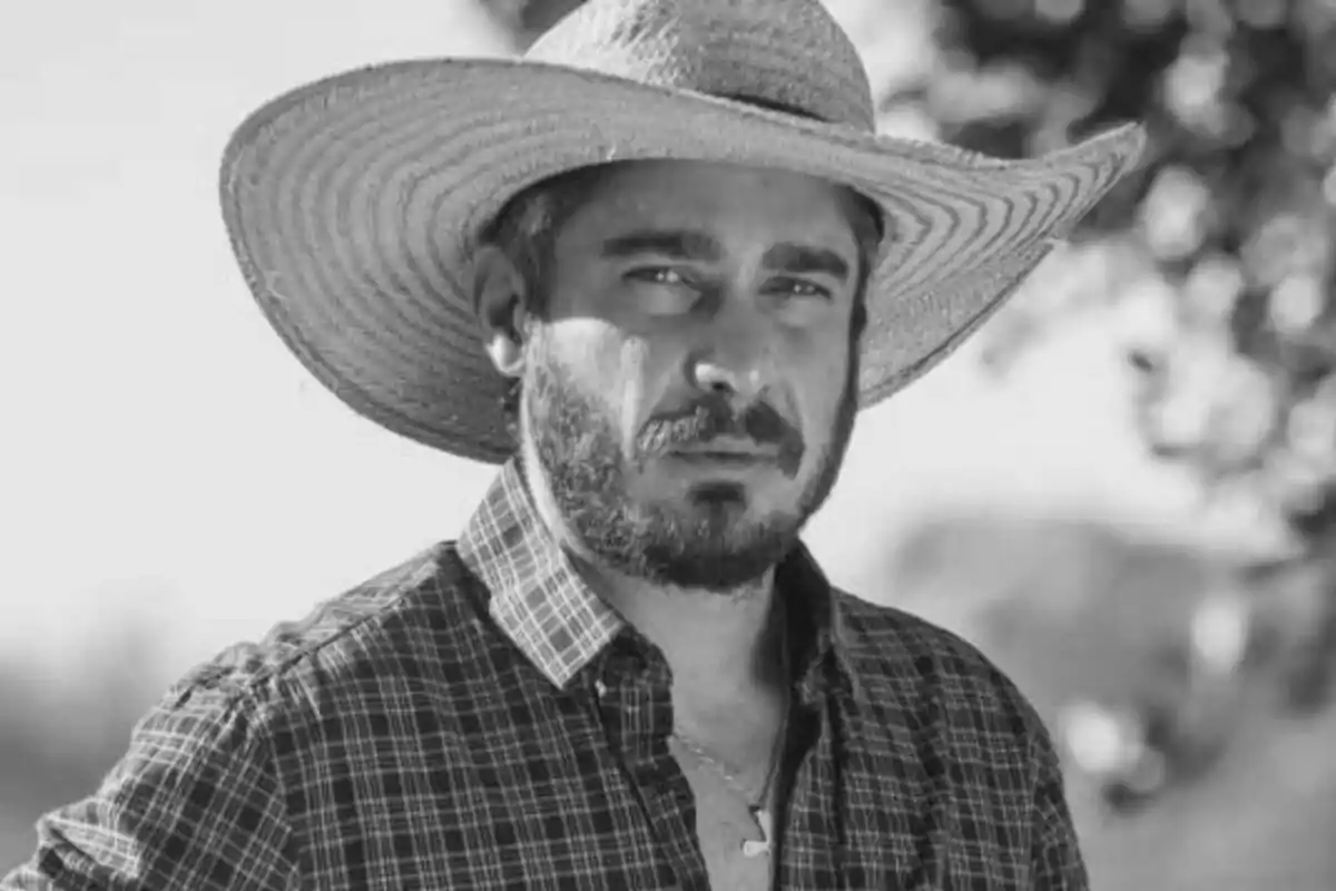 Fotografía en blanco y negro del actor Tommy Schiavo con sombrero de paja y camisa a cuadros