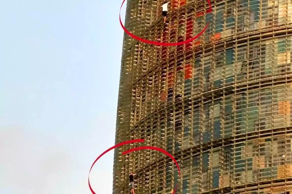 Imagen de los dos hombres escalando la Torre Glòries en Barcelona