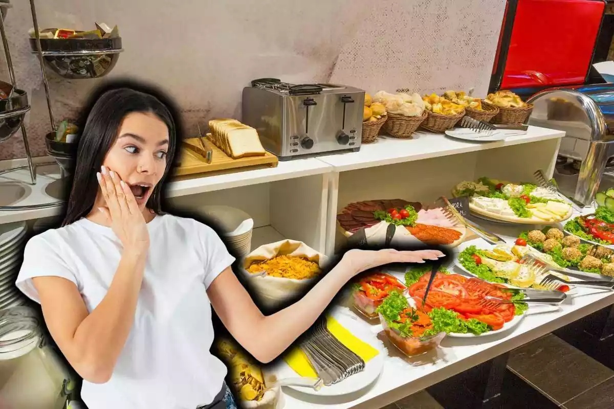 Mujer joven morena con camiseta blanca sorprendida mostrando con la mano izquierda extendida sobre fondo de buffet de desayuno libre