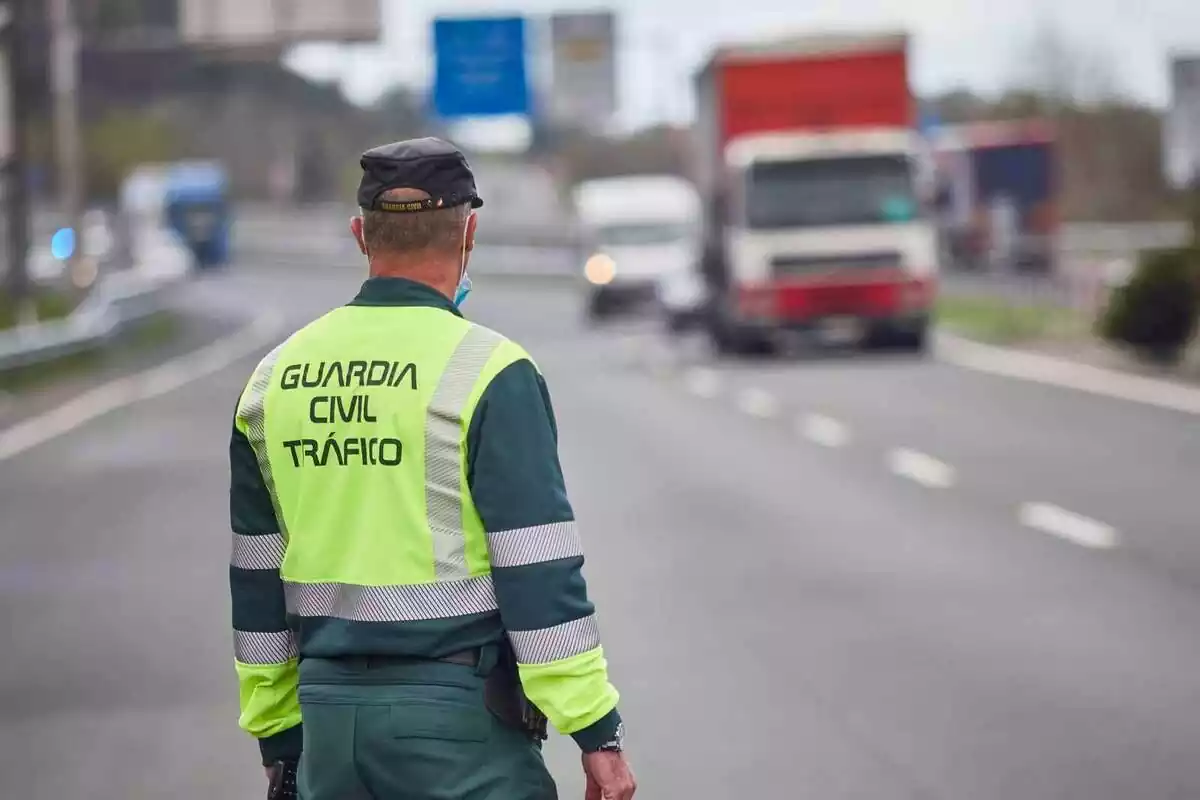 Agente de la Guardia Civil de Tráfico en la carretera y con vehículos de fondo