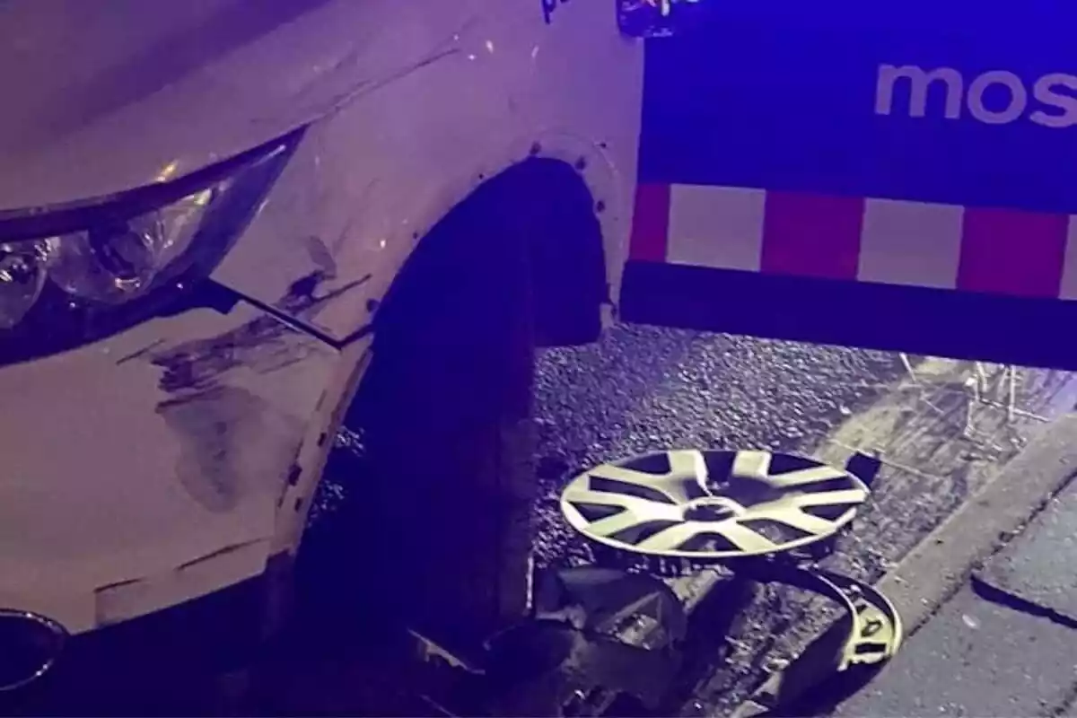 Imagen de un coche de los Mossos d'Esquadra con la rueda rota por haber sufrido un accidente