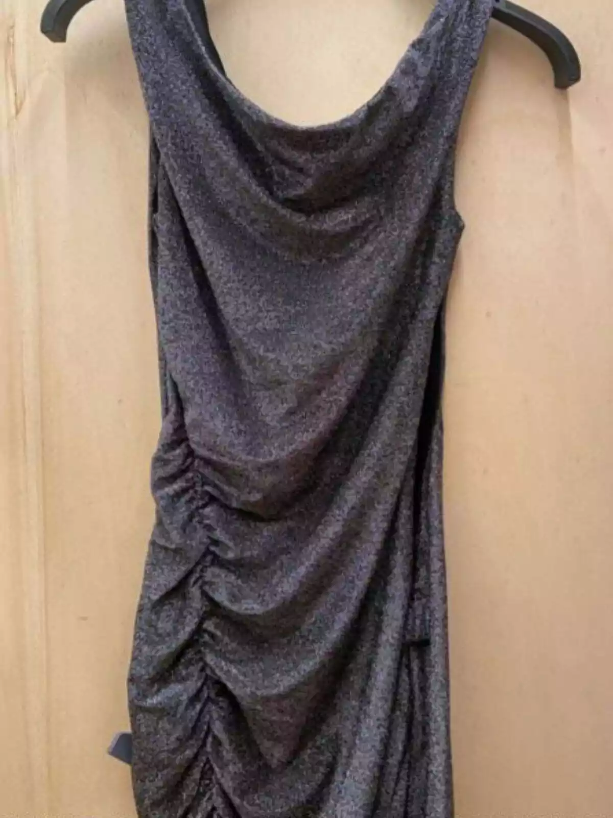 Imagen de un vestido de Bershka con brillos en tono plata colgado de una percha Imagen de un vestido de Bershka con brillos en tono plata colgado de una percha