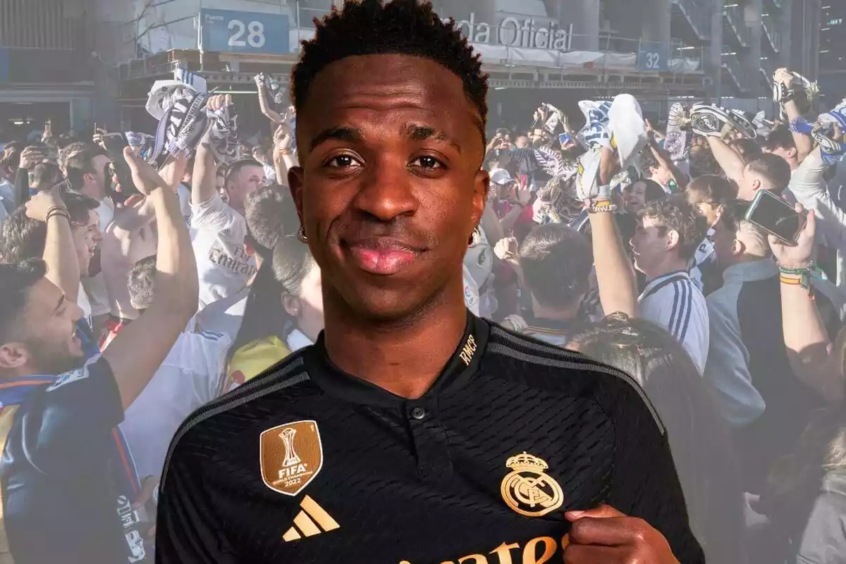 Vinícius Júnior se señala el escudo del Real Madrid mientras los aficionados celebran