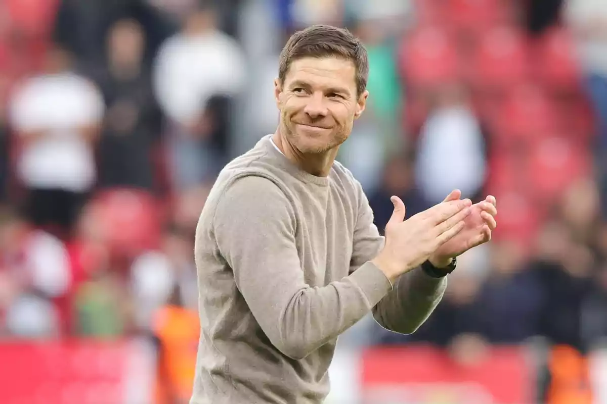 Un hombre aplaudiendo y sonriendo en un estadio con fondo desenfocado. Un hombre aplaudiendo y sonriendo en un estadio con fondo desenfocado.