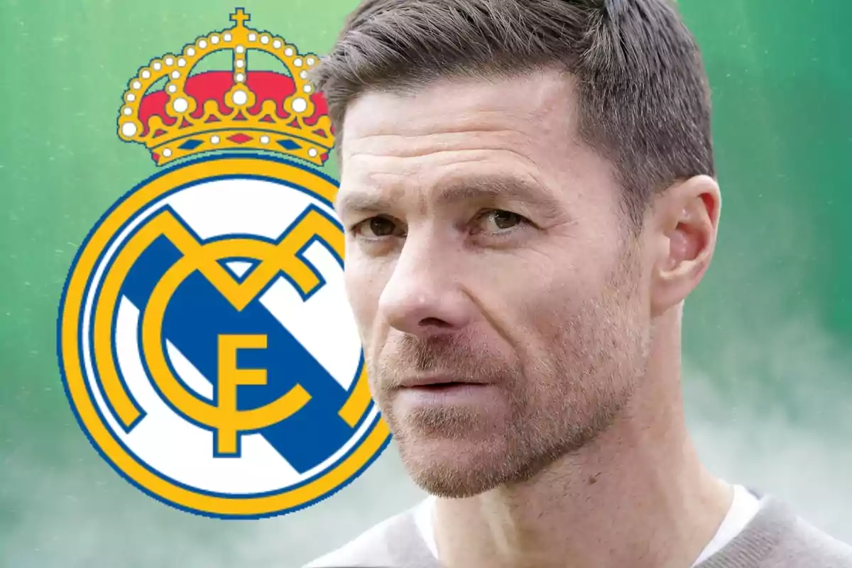 Un hombre de cabello corto y barba ligera está frente al escudo del Real Madrid sobre un fondo verde.