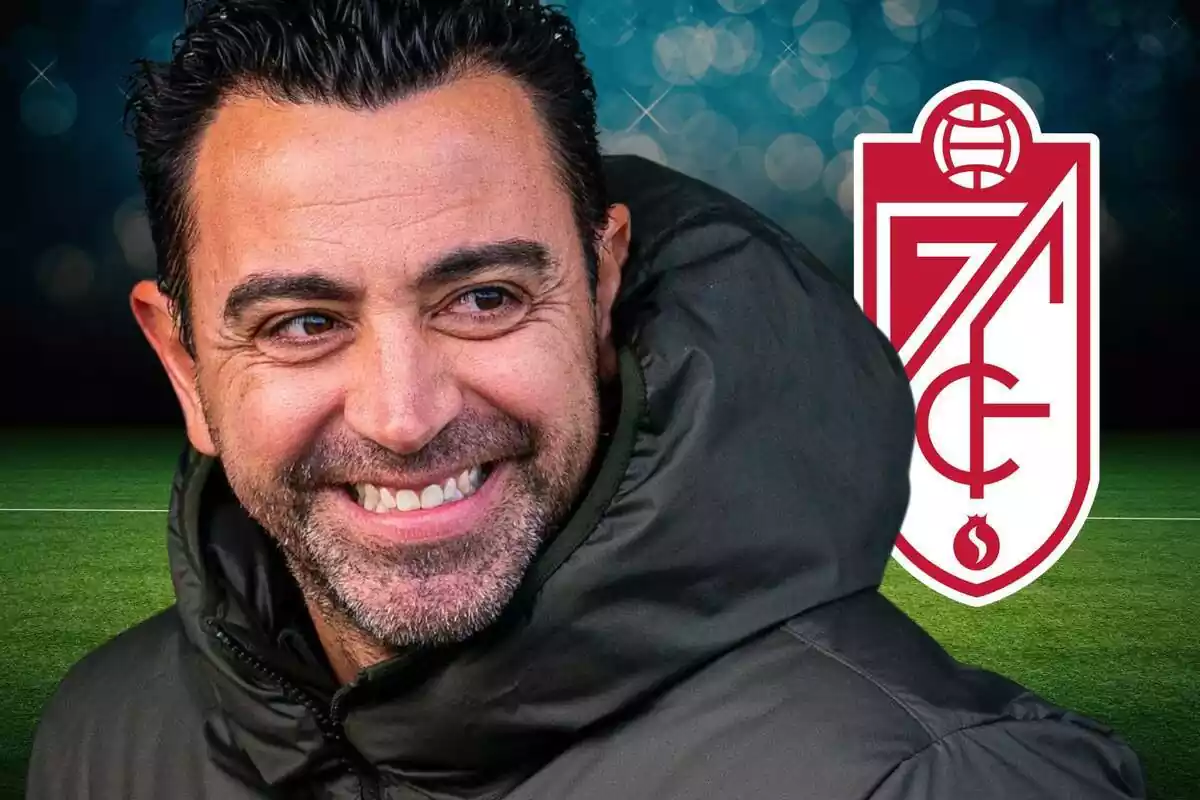 Xavi Hernández con una gran sonrisa mirando de reojo al escudo del Granada CF