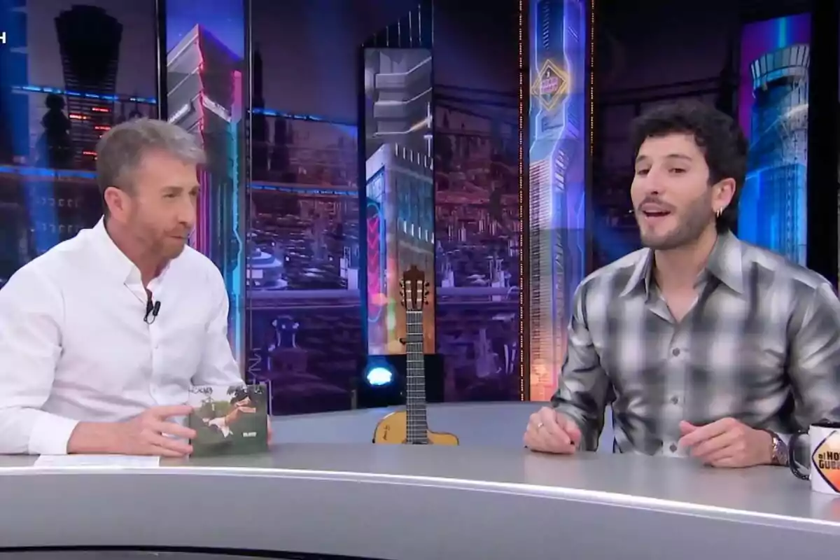 Pablo Motos y Sebastián Yatra conversan con un fondo colorido y una guitarra en el centro de la mesa en 'El Hormiguero'. Pablo Motos y Sebastián Yatra conversan con un fondo colorido y una guitarra en el centro de la mesa en 'El Hormiguero'.